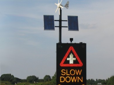 Solar panels situated on a sign that declares drivers to SLOW DOWN